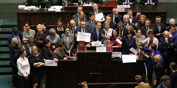 Posłowie opozycji blokują mównicę na Sali Plenarnej Sejmu. W centrum: Kamila Gasiuk-Pihowicz pokazuje znak „V”.