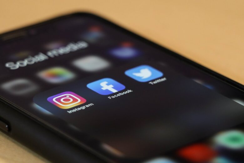 Smartfon z ikonami social mediów na ekranie: Instagram, Facebook, Twitter
