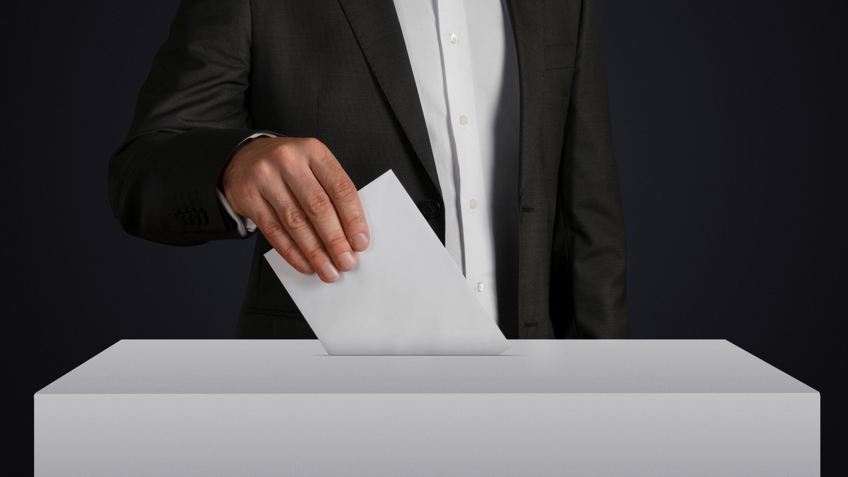 Mężczyzna wkładający kartę do głosowania do urny wyborczej